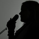 Eine Person hat einen Telefonhörer in der Hand