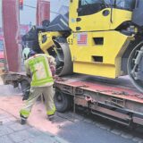 Die Feuerwehr streut eine Öllache an einem Tieflader ab.