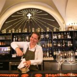 Eine Mitarbeiterin vom Dortmunder Restaurant Emil Grill & Meer steht hinter der Theke und öffnet eine Weinflasche