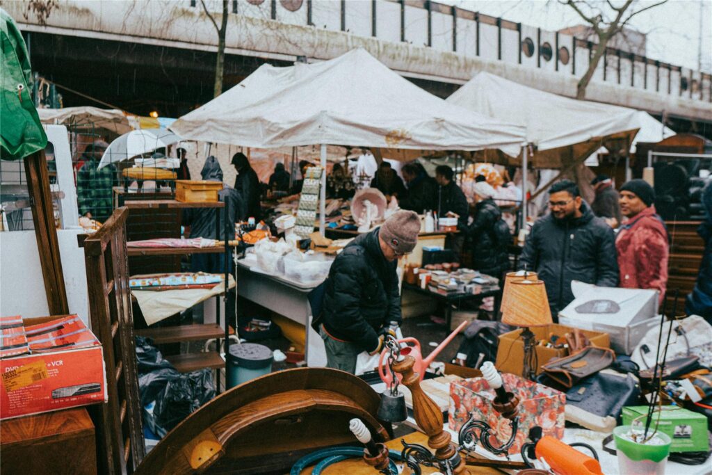 Passanten in Winterjacken sehen sich die gefüllten Stände auf einem Trödelmarkt in NRW an.