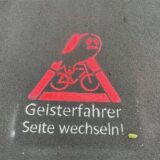 Piktogramm mit der Aufschrift „Geisterradler Seite wechseln“ auf einem Radweg