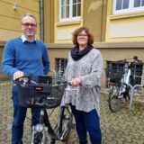 Ein Mann und eine Frau stehen an einem Fahrrad vor dem Dattelner Rathaus.