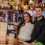Jaqueline Schleich und Jannik Valtin stehen hinter der Theke an der Zapfanlage ihrer Kneipe in Recklinghausen.