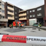 Auf dem Place d’Arras in der Hertener Innenstadt stehen Einsatzkräfte und Fahrzeuge der Polizei und der Feuerwehr. Im Bildvordergrund ist ein rot-weißes Flatterband mit dem Aufdruck Polizeiabsperrung zu sehen.