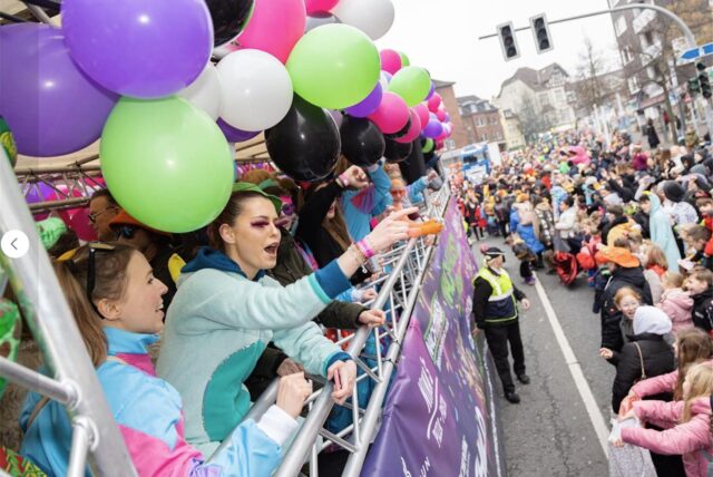 Rosenmontagszug in Recklinghausen: Kostümierte Frauen winken von einem Wagen in die Menge.