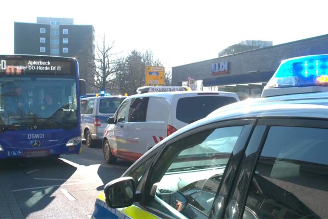 Ein blauer Bus steht an einer Bushaltestelle in Dortmund-Hörde. Er ist umringt von Einsatzfahrzeugen.