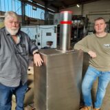 Zwei Männer stehen vor einem versenkbaren Metall-Poller.