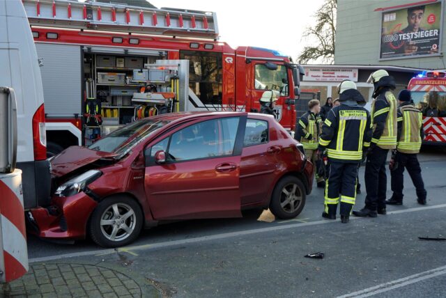 Ein Auto mit kaputter Front, die in einem Transporter hängt.