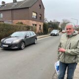 Christian Friedrich, Vorsitzender der Siedlergemeinschaft Herten-Süd, deutet an der Königsberger Straße auf einen vorbeifahrenden grauen Pkw.