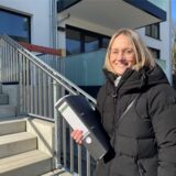 Daniele Moge, die sich um die Vermietung der neuen Wohnungen in der Neu-Crengeldanz-Straße in Lütgendortmund kümmert, steht mit einem Aktenordner in der Hand am Treppenaufgang zu einem der neuen Häuser.