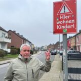 Christian Friedrich steht an der Königsberger Straße und deutet mit dem Zeigefinger auf ein rotes Schild.