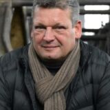 Bild-Montage: Links ein Luftbild des Rathauses, rechts ein Porträt von Martin Cremer.