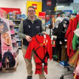 Fabian Trommler hält ein Ninja-Kostüm in der Hand.
