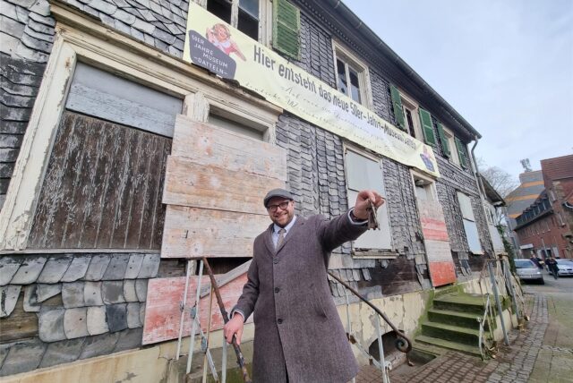 Ein Mann steht vor dem alten Wirxel-Haus in Datteln und hält einen Schlüssel in der Hand.