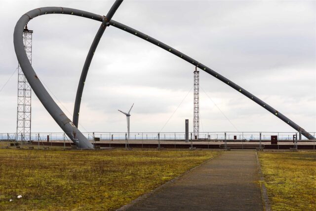 Der Blick durch die Bögen des Horizont-Observatoriums in Herten auf das Windrad der Nachbarhalde Hoppenbruch.