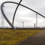 Der Blick durch die Bögen des Horizont-Observatoriums in Herten auf das Windrad der Nachbarhalde Hoppenbruch.