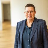 Die Dortmunder Sozialdezernentin Birgit Zoerner steht im Rathaus und lächelt in die Kamera.