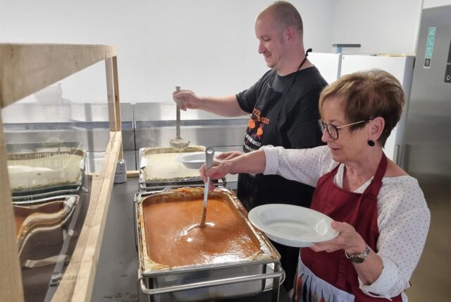 Zwei Personen geben Essen aus.