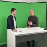 Andreas Thiveßen und Felix Abrahams stehen im Studio der Ruhr Nachrichten vor einem Greenscreen und unterhalten sich.