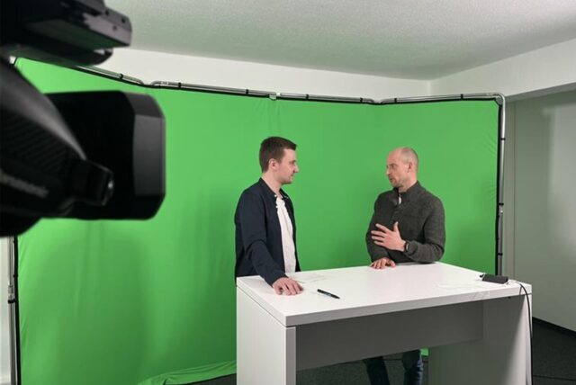 Andreas Thiveßen und Felix Abrahams stehen im Studio der Ruhr Nachrichten vor einem Greenscreen und unterhalten sich.
