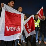 Verdi-Mitglieder bei einem Warnstreik mit Fahnen in der Hand.