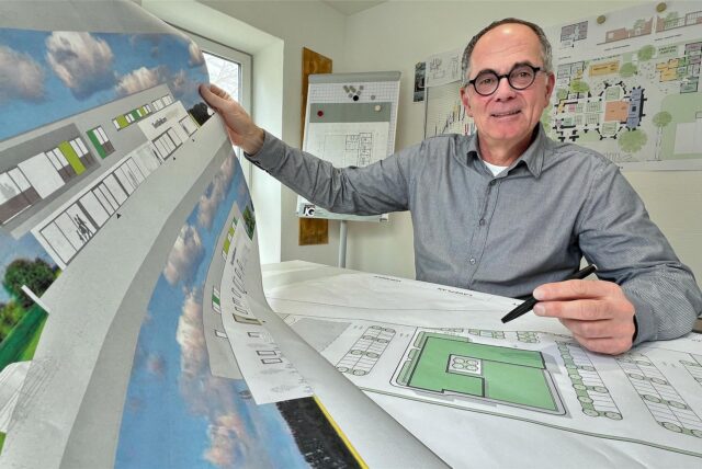 Architekt Jochen Grimm aus Holzwickede zeigt in seinem Büro einen Entwurfsplan für die neue Tierfachklinik, auf dem Tisch liegt ein Lageplan.