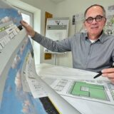 Architekt Jochen Grimm aus Holzwickede zeigt in seinem Büro einen Entwurfsplan für die neue Tierfachklinik, auf dem Tisch liegt ein Lageplan.