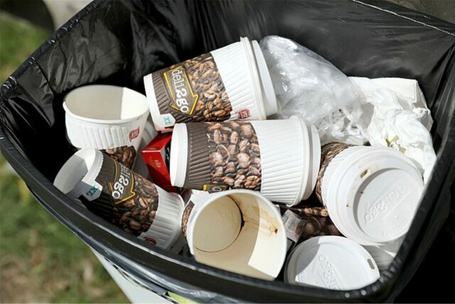Leere To-Go-Kaffeebecher in einem Mülleimer
