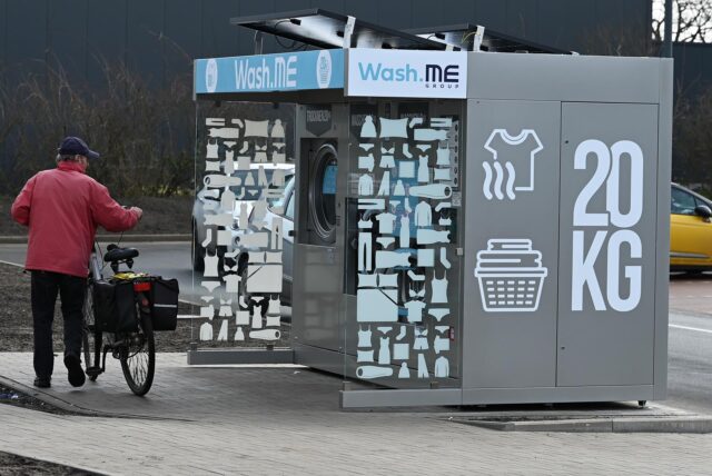 Ein Fahrradfahrer schaut sich den neuen SB-Waschautomaten vor dem neuen Fressnapf in Dorsten an.