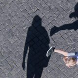 Ein Junge hampelt hinter dem Rücken einer Frau herum
