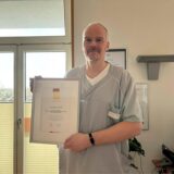 Dr. Lars Heining vom Sixtus-Hospital in Haltern hält eine Urkunde hoch