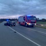 Ein Unfallauto steht mit geöffneter Fahrertür auf einer Brücke, daneben steht ein Feuerwehrauto. Im Hintergrund ist ein Einsatzfahrzeut der Polizei zu erkennen.