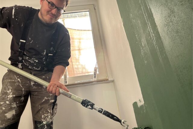 Robin Conrad streicht seine Wand grün.