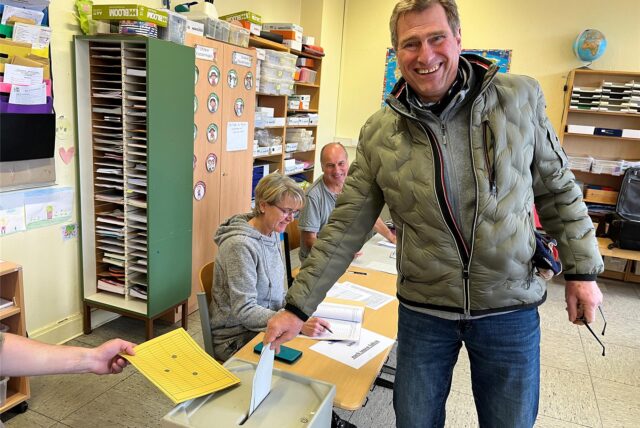 Rainer Vierhaus steckt seinen Wahlzettel bei der Bundestagswahl 2025 in Haltern in die Urne.