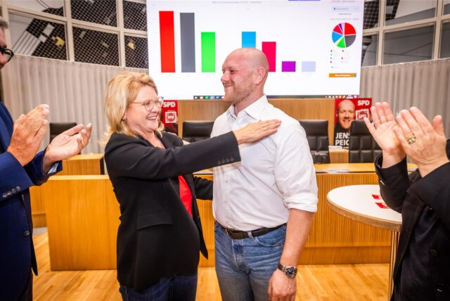 Am Abend der Bundestagswahl 2025 umarmen sich die SPD-Direktkandidaten Sabine Poschmann (l.) und Jens Peick, während Parteifreunde klatschen.