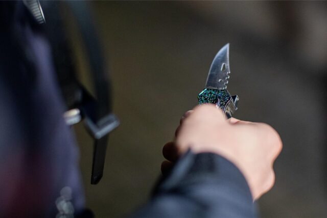 Ein Polizist hält ein sichergestelltes Messer in der Hand. (Symbolfoto)