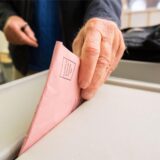 Wahlunterlagen in die Wahlurne geworfen
