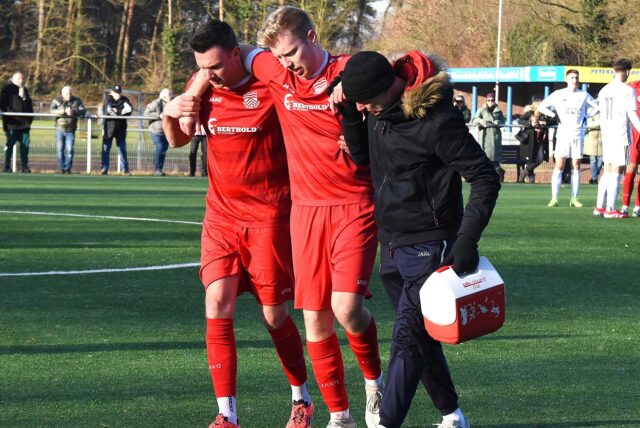 Der verletzte Phil Schröter wird von Lucas Mann und einem Betreuer vom Feld geführt
