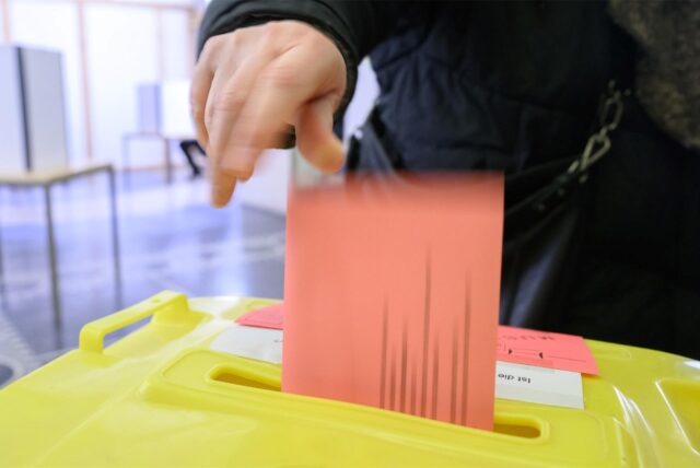 Eine Frau wirft ihren Wahlzettel für die Bundestagswahl 2025 in eine Urne.