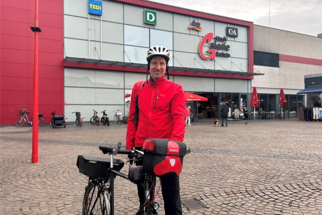 Ein Mann in roter Jacke und weißem Fahrradhelm steht vor der Stadtgalerie in Datteln.