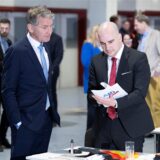 Björn Höcke, im schwarzen Anzug, steht auf der linken Seite des Bildes und schaut auf Robert Teske, auch im schwarzen Anzug.