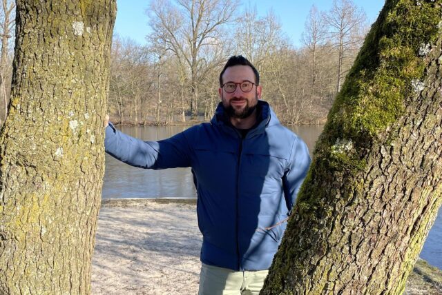 Steffen Eich steht zwischen zwei Bäumen am Pilina Beach im Revierpark Wischlingen.