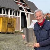 Franz Engel hält eine Dachziegel in der Hand, im Hintergrund die Laurentius-Kirche.