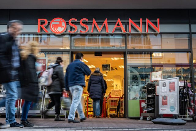 Passanten gehen in einer Fußgängerzone an einer Rossmann-Filiale vorbei.