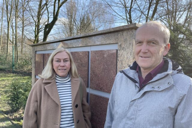 Sabine Schürmann und Josef Feld stehen vor einer Urnenwand auf dem katholischen Friedhof in Lütgendortmund.
