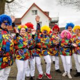 Frauen und Männer stehen verkleidet in Clownsanzügen in Haltern-Hullern vor einem.