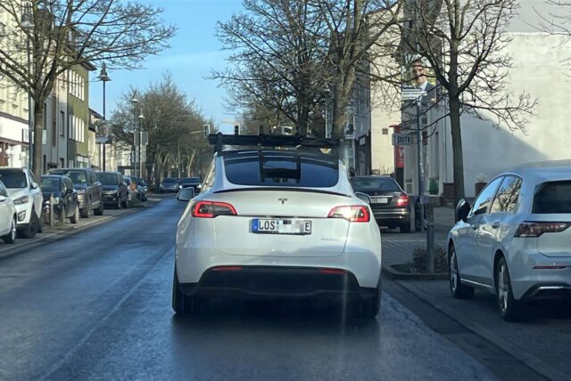 Ein Tesla Fleet Validation Car mit auffälliger Sensorik von hinten während der Fahrt fotografiert. Die speziellen Aufbauten sind gut zu erkennen.
