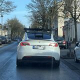Ein Tesla Fleet Validation Car mit auffälliger Sensorik von hinten während der Fahrt fotografiert. Die speziellen Aufbauten sind gut zu erkennen.