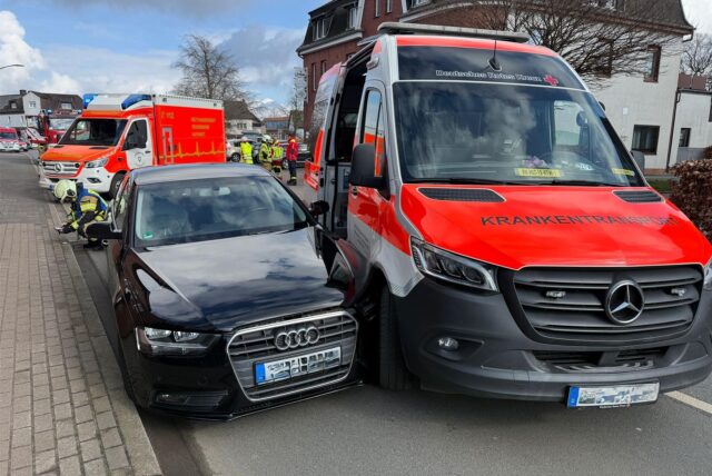 Zwei verbeulte Autos stehen nebeneinander auf der Straße.