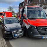 Zwei verbeulte Autos stehen nebeneinander auf der Straße.